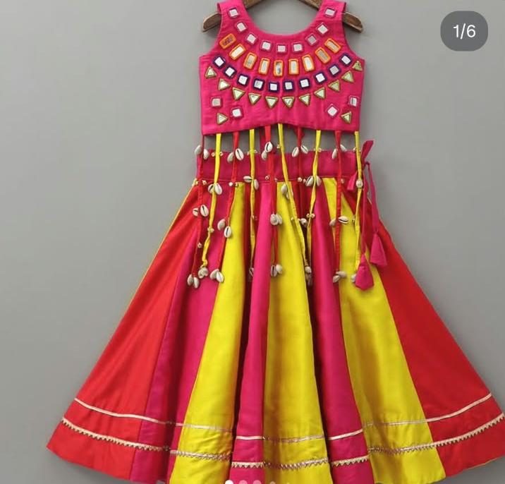 Front view of girls' red and yellow lehenga choli with shell tassels and a flared panelled skirt